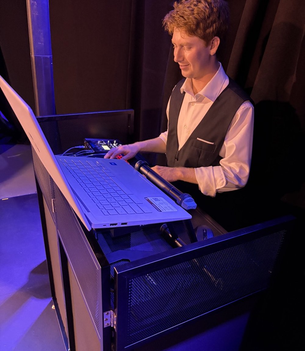 Austin, producer at Rapid City Productions, running the booth at a live event